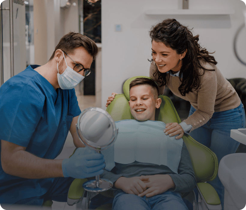 Dentist showing young patient a mirror
