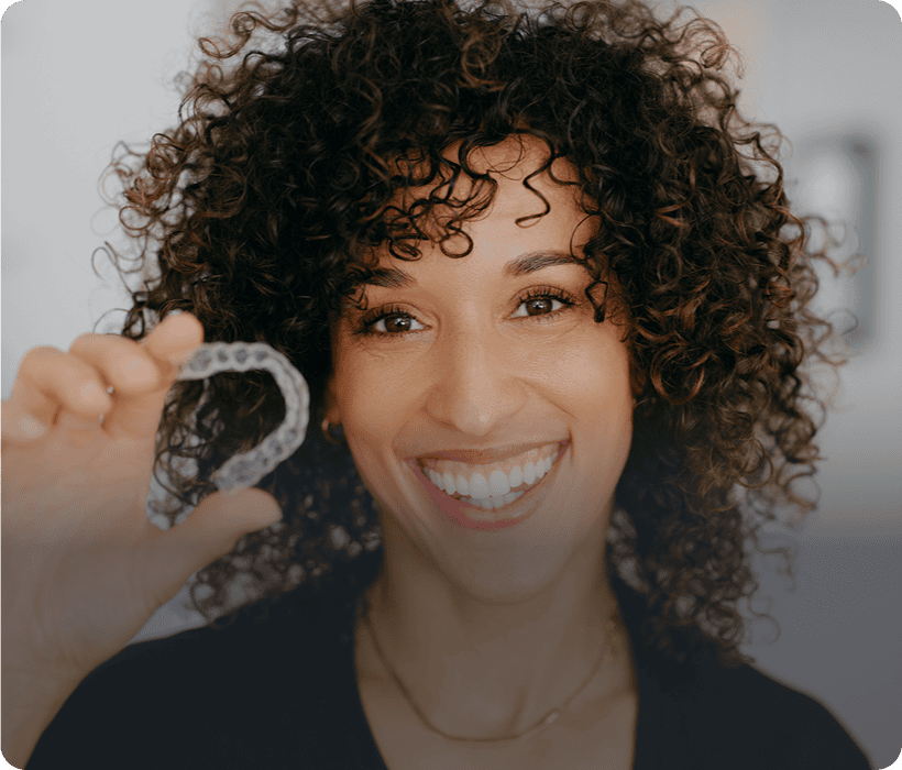 Happy person displaying teeth aligner device