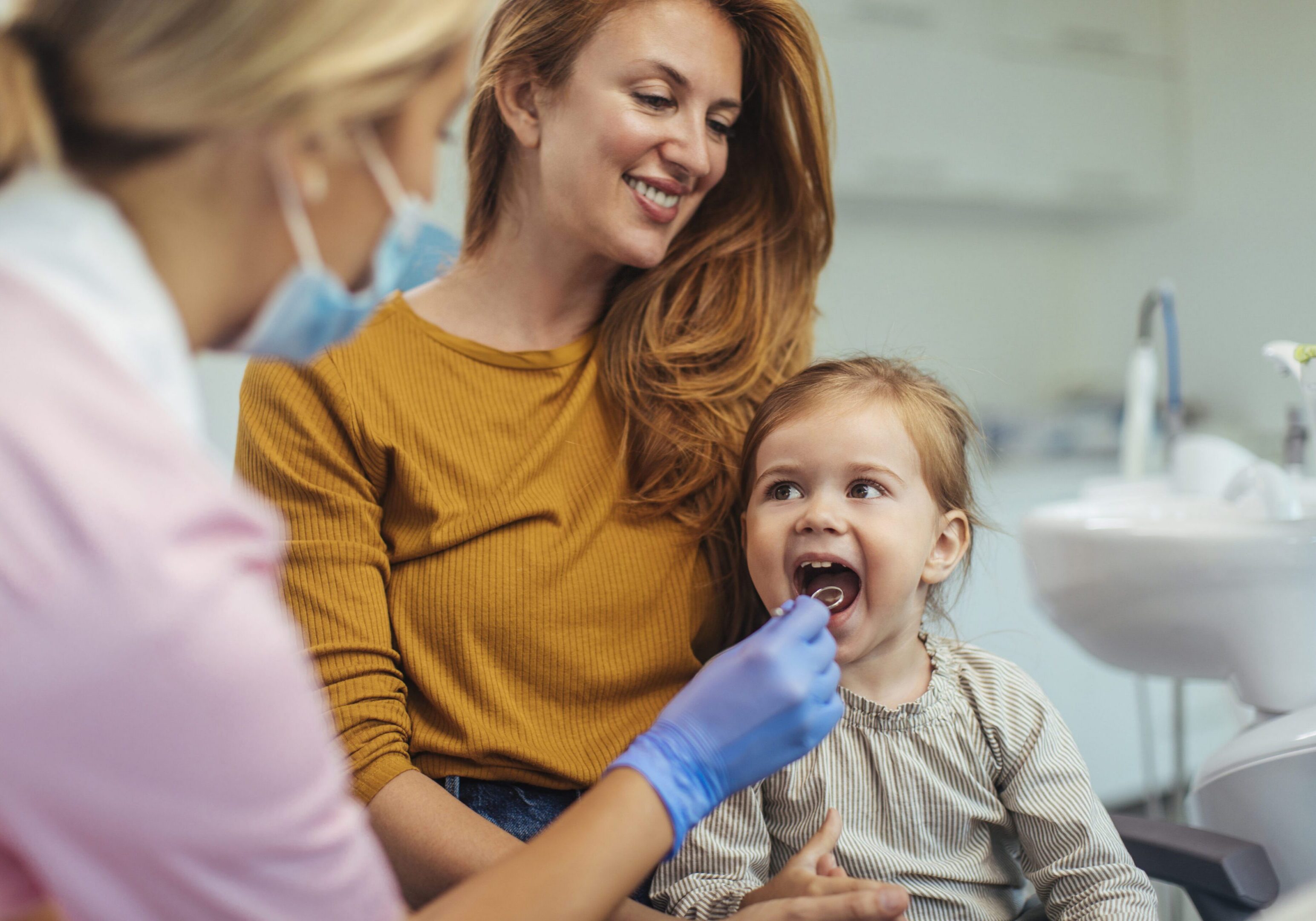 Young girl having her dental check up done by a young female dentist